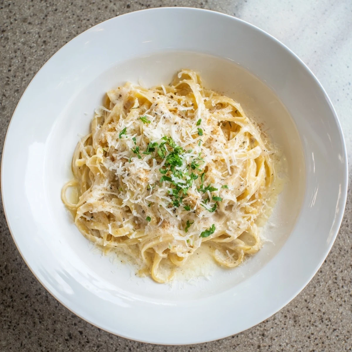 Steaming bowl of the perfect 20-minute creamy Alfredo pasta, rich with Parmesan and parsley.