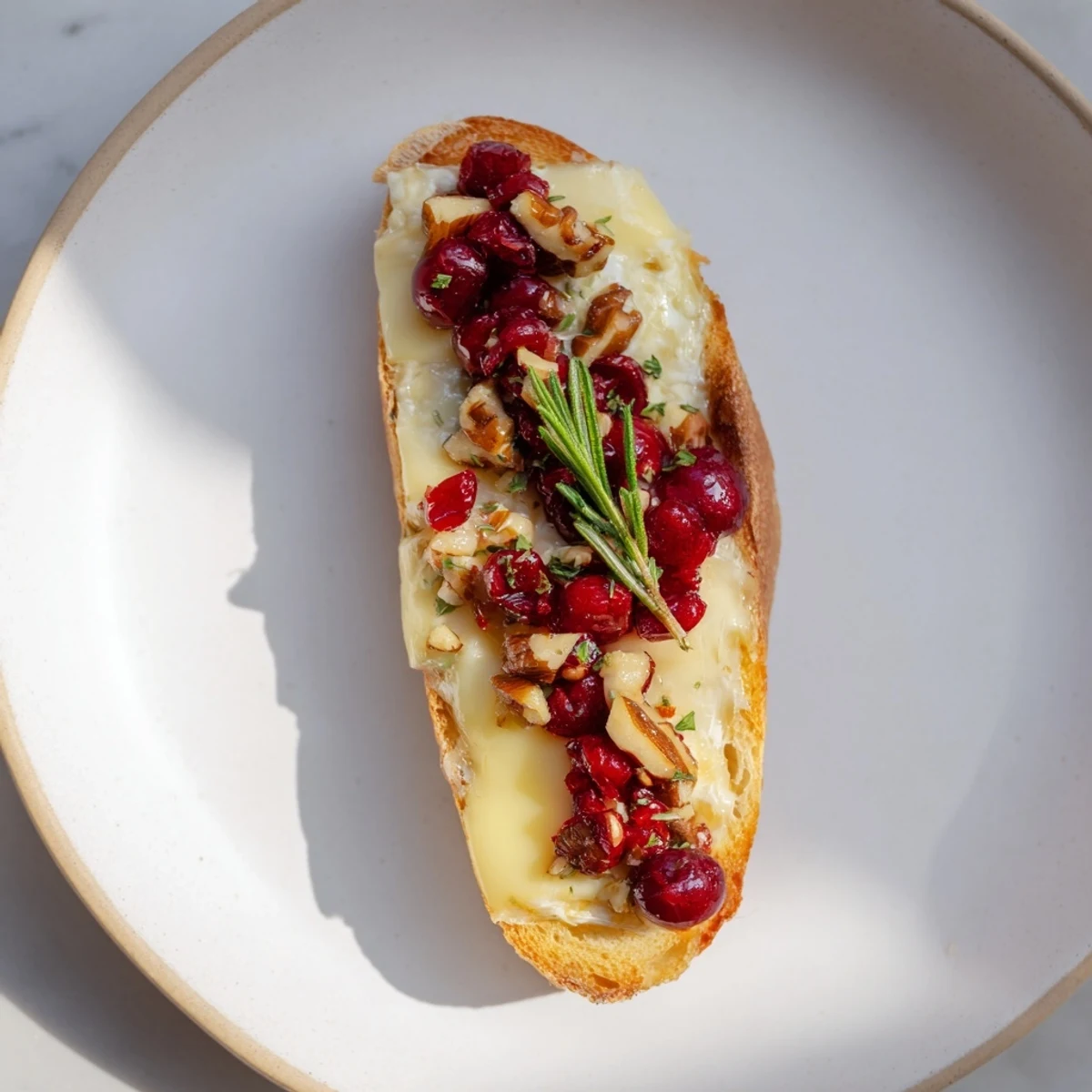 Golden, toasted Festive Holiday Cranberry and Brie Crostini, topped with bubbly cranberry sauce and creamy brie.