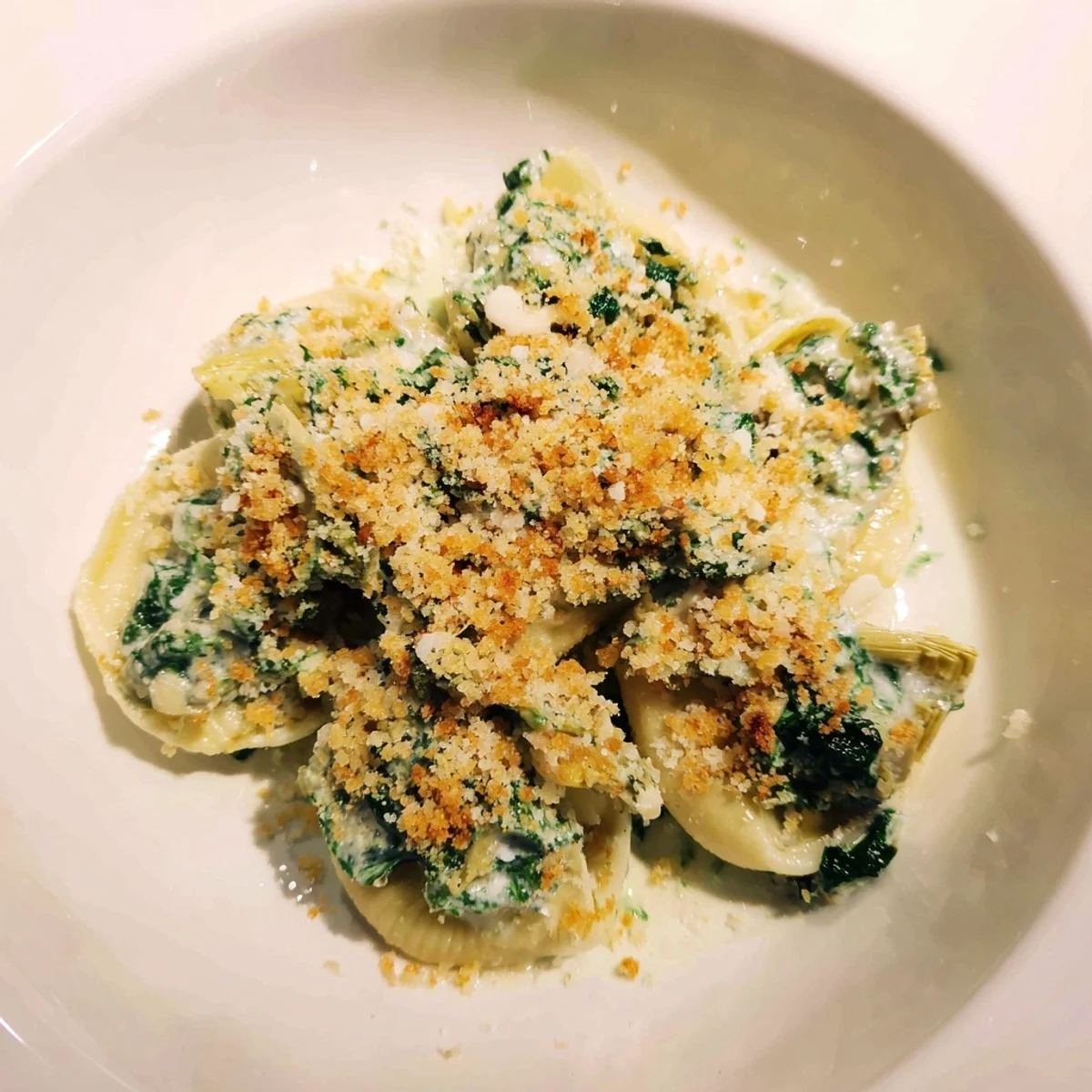 Golden, bubbly Creamy Spinach and Artichoke Stuffed Mushrooms ready to serve as a warm appetizer.