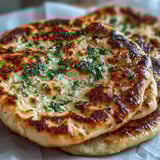 A side view of The Best Easy Garlic Naan Bread, perfect for scooping up rich curry.