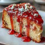 Moist, gluten-free Blood Orange Polenta Cake ready to be sliced, topped with glaze.