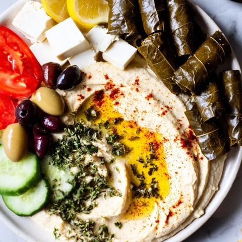 A colorful Turkish Meze platter displays creamy hummus, fresh veggies, and a variety of cheeses.