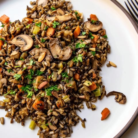 Steaming Wild Rice and Mushroom Pilaf, featuring tender grains and earthy sautéed mushrooms in a savory broth.  