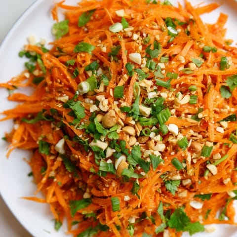 Fresh, crunchy Spicy Carrot Salad with bright orange carrots and a zesty, Asian-inspired dressing.