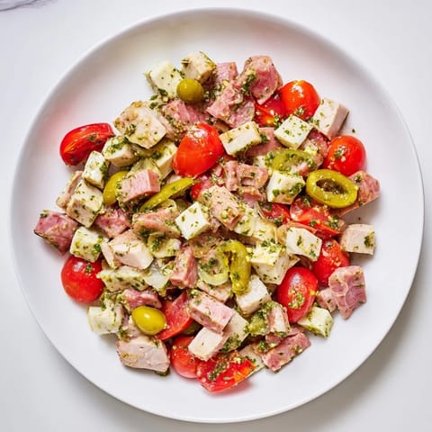 Colorful bowl of Italian Deli Chopped Chicken Salad featuring crisp romaine, pepperoncini, and juicy cherry tomatoes.