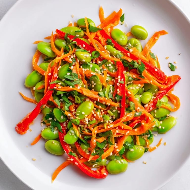 Close-up of a bowl of Asian edamame salad showcasing bright vegetables and savory dressing.