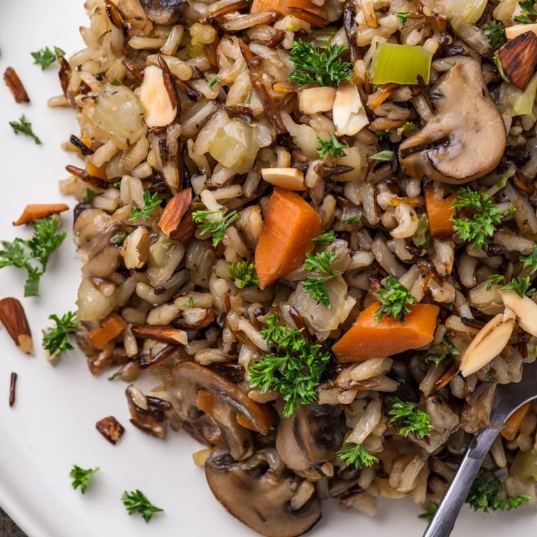 A close-up of finished Wild Rice and Mushroom Pilaf garnished with fresh parsley and toasted almonds.  
