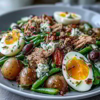 A vibrant Spring Niçoise Salad featuring tender tuna, crisp vegetables, and soft-boiled eggs.