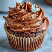 Taurus birthday cupcakes with terracotta buttercream, beautifully swirled and topped with edible gold stars for a luxurious touch.